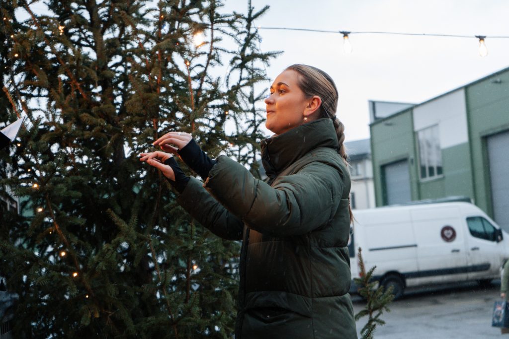  Biedrības “Tavi draugi” kora vadītāja diriģē "Angāra Ziemassvētku" labdarības mini koncerta laikā 15.12.2024.